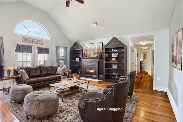 living room with light hardwood / wood-style floors, high vaulted ceiling, and ceiling fan