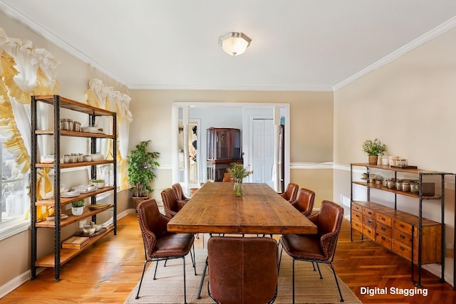dining space featuring wood finished floors, baseboards, and ornamental molding