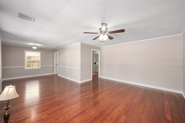 unfurnished room featuring baseboards, visible vents, dark wood-style flooring, and ornamental molding