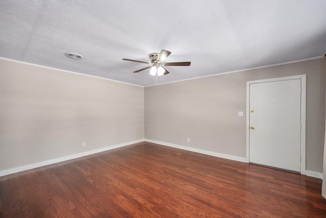 empty room featuring dark wood-style floors, baseboards, visible vents, and crown molding