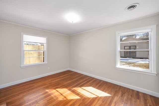 spare room featuring ornamental molding, visible vents, and baseboards