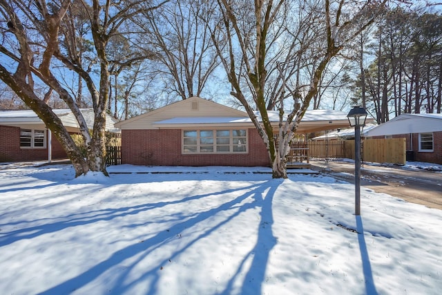 view of front of home featuring brick siding and fence