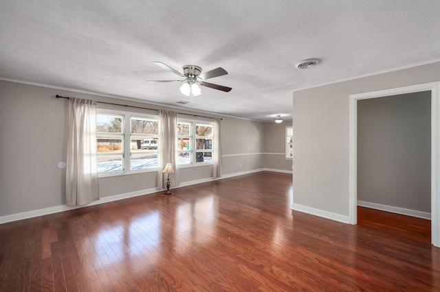 spare room with baseboards, visible vents, a ceiling fan, dark wood-style flooring, and a textured ceiling