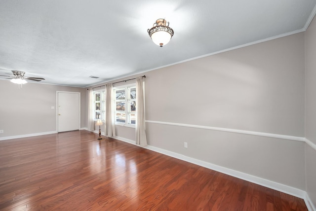 interior space featuring visible vents, ornamental molding, ceiling fan, wood finished floors, and baseboards