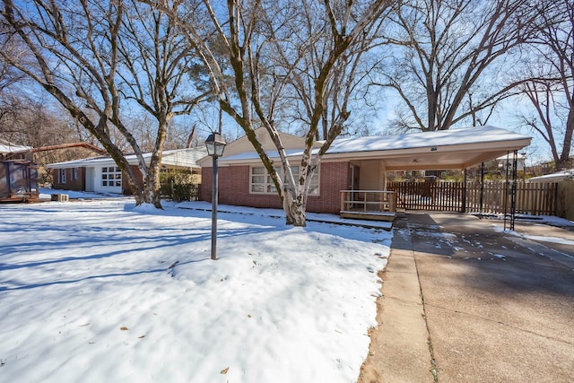 single story home featuring driveway, fence, a carport, and brick siding