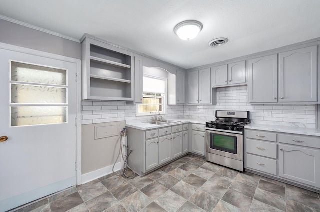 kitchen featuring gas range, light countertops, a sink, and gray cabinetry