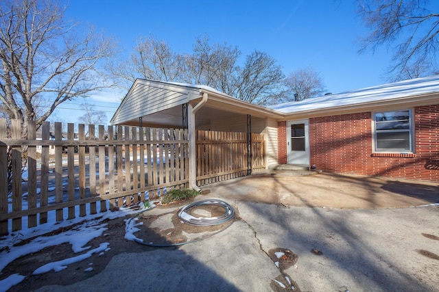 view of side of property with brick siding and fence