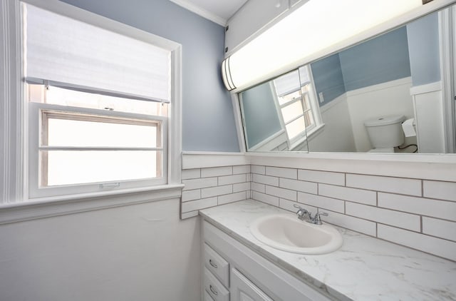 bathroom with toilet, decorative backsplash, and vanity