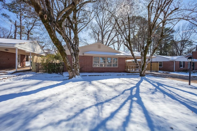 ranch-style house featuring fence and brick siding