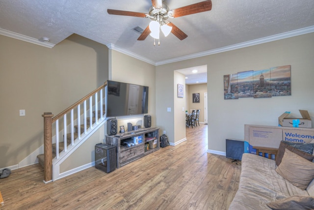 living room with wood-type flooring, a textured ceiling, and crown molding