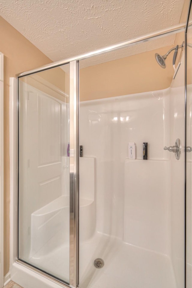 bathroom featuring walk in shower and a textured ceiling