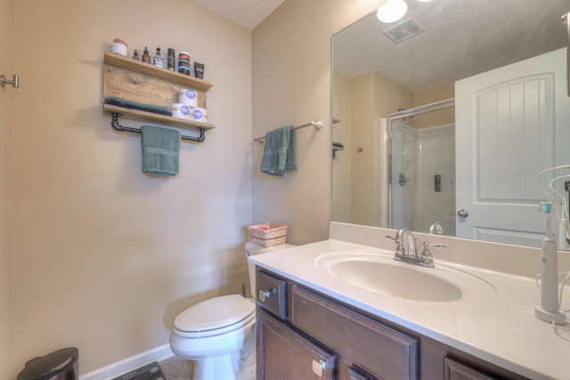 bathroom with a shower with door, vanity, and toilet