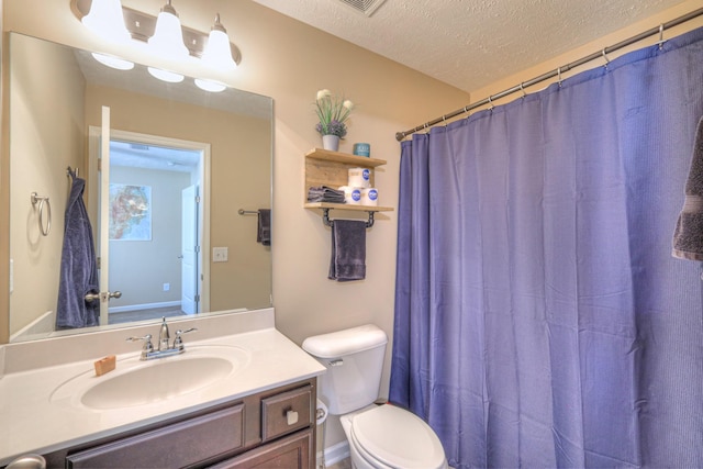 bathroom featuring a shower with curtain, vanity, toilet, and a textured ceiling