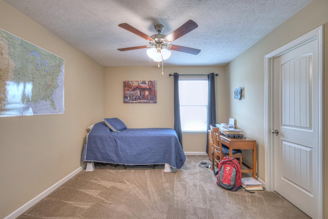 carpeted bedroom with ceiling fan and a textured ceiling