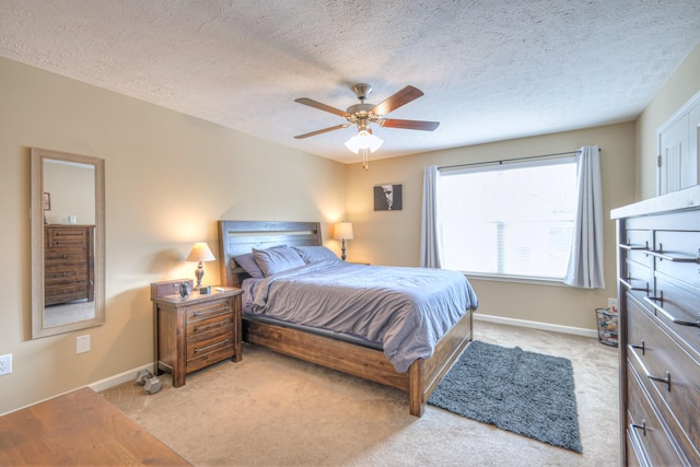 carpeted bedroom featuring a textured ceiling and ceiling fan