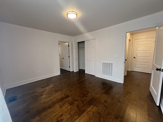 unfurnished bedroom featuring dark wood-type flooring and a closet