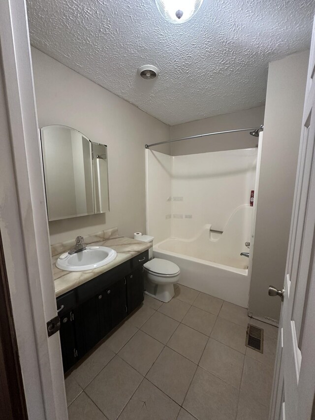 full bathroom with toilet, bathing tub / shower combination, a textured ceiling, vanity, and tile patterned flooring