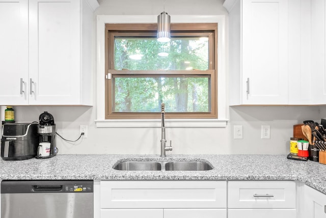 kitchen featuring dishwasher, sink, light stone countertops, and white cabinets