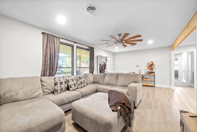 living room featuring beam ceiling, light hardwood / wood-style flooring, and ceiling fan