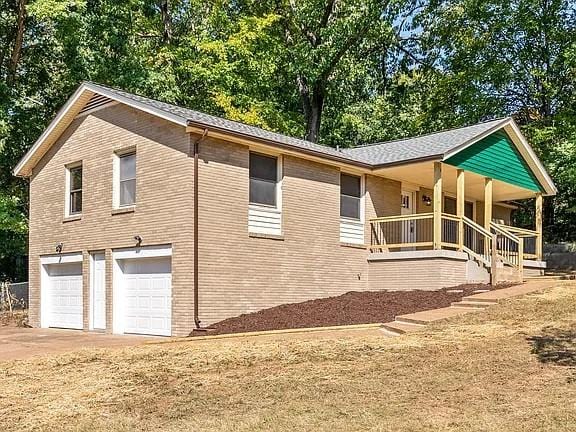 view of property exterior with a garage and covered porch