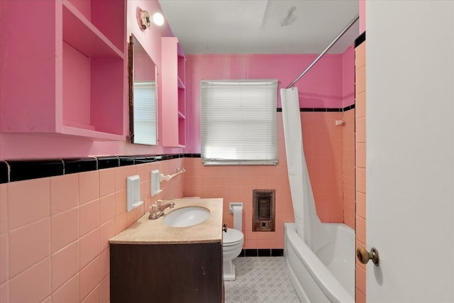 full bathroom featuring shower / bath combo, tile walls, heating unit, vanity, and toilet