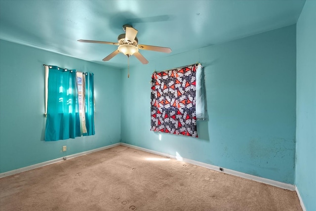 carpeted spare room featuring ceiling fan