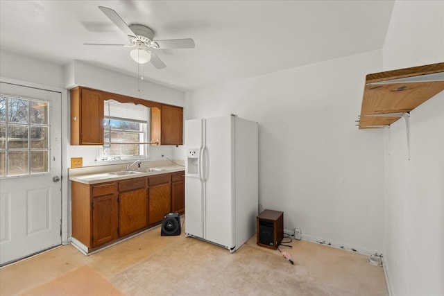 kitchen with ceiling fan, sink, and white fridge with ice dispenser