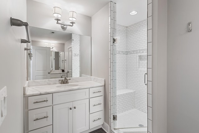 bathroom featuring vanity and a shower with door