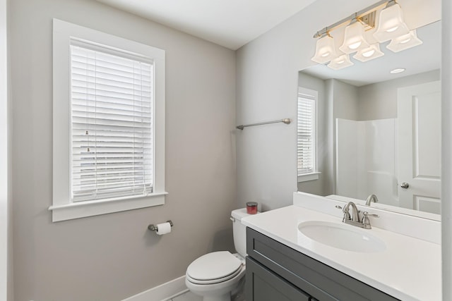 bathroom featuring vanity, walk in shower, and toilet