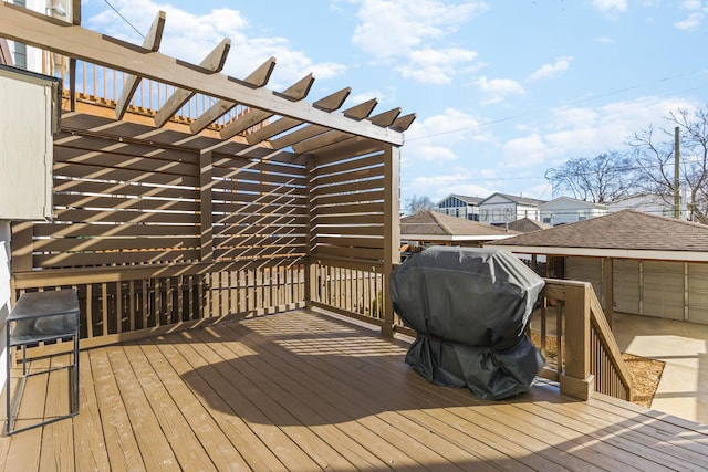 wooden deck featuring a grill and a pergola