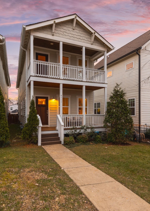 view of front of property with a porch, a balcony, and a yard