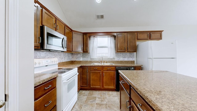 kitchen featuring lofted ceiling, sink, white appliances, and decorative backsplash