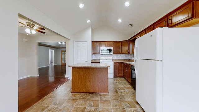 kitchen featuring white appliances, light hardwood / wood-style flooring, ceiling fan, a center island, and tasteful backsplash