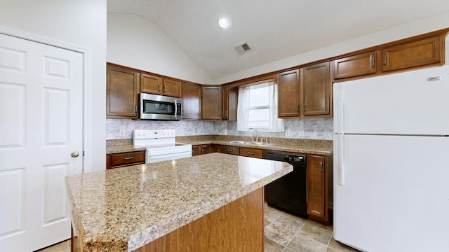 kitchen featuring light stone countertops, a kitchen island, sink, and white appliances