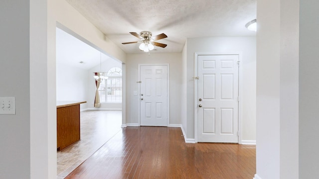 entryway featuring hardwood / wood-style flooring, ceiling fan, vaulted ceiling, and a textured ceiling