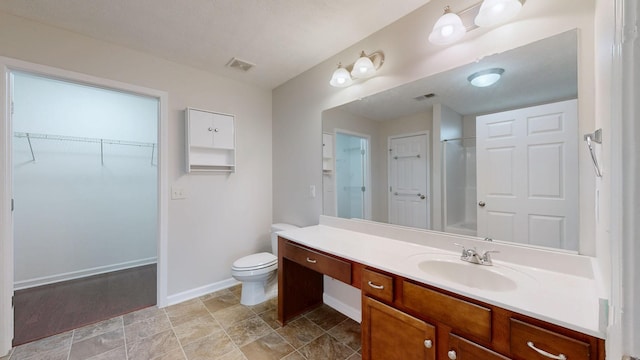 bathroom with vanity, a shower, and toilet