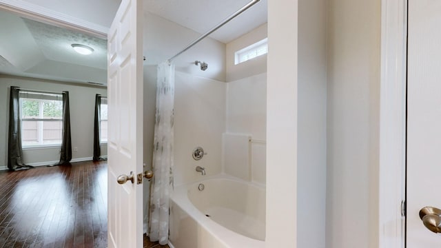 bathroom with hardwood / wood-style flooring, plenty of natural light, and shower / bathtub combination with curtain