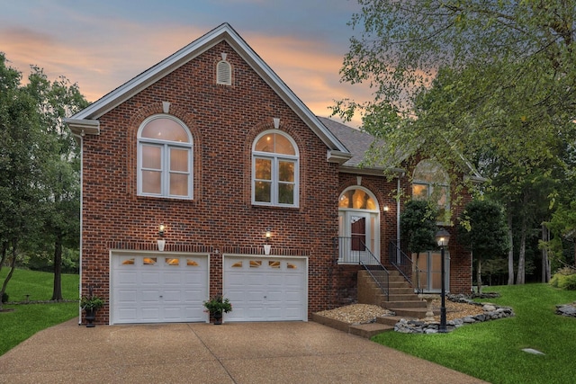 view of front of property with a garage and a lawn