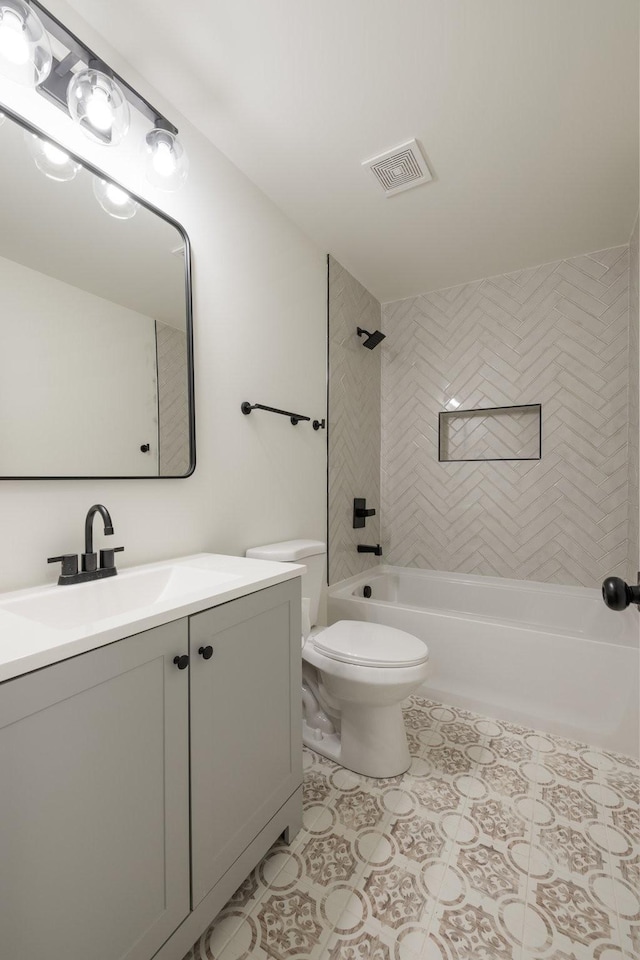 full bathroom with vanity, tiled shower / bath combo, tile patterned floors, and toilet