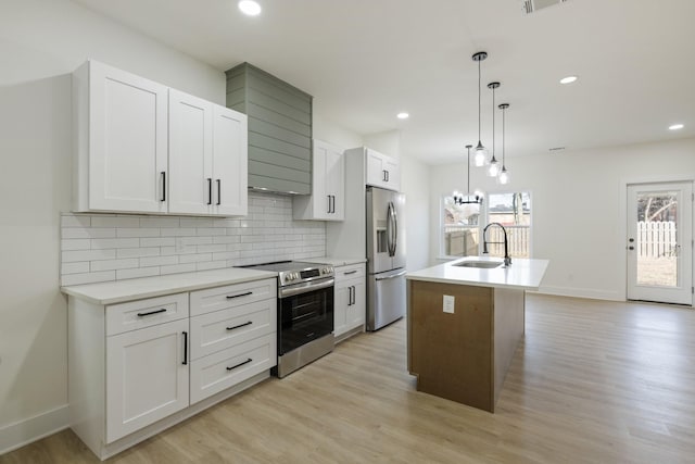 kitchen with sink, hanging light fixtures, a center island with sink, appliances with stainless steel finishes, and white cabinets