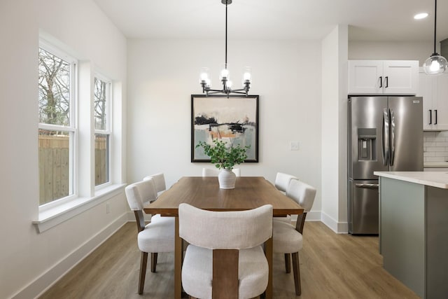 dining area featuring light hardwood / wood-style floors and a notable chandelier