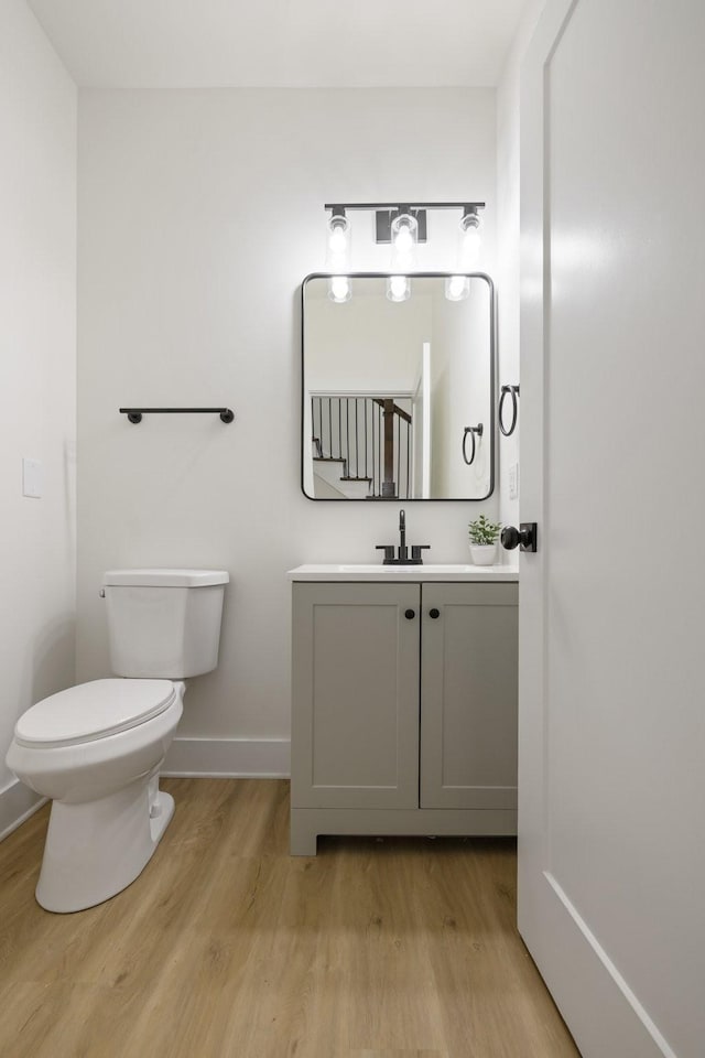 bathroom with vanity, hardwood / wood-style flooring, and toilet