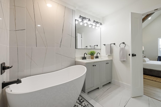 bathroom with a bathing tub, lofted ceiling, and vanity