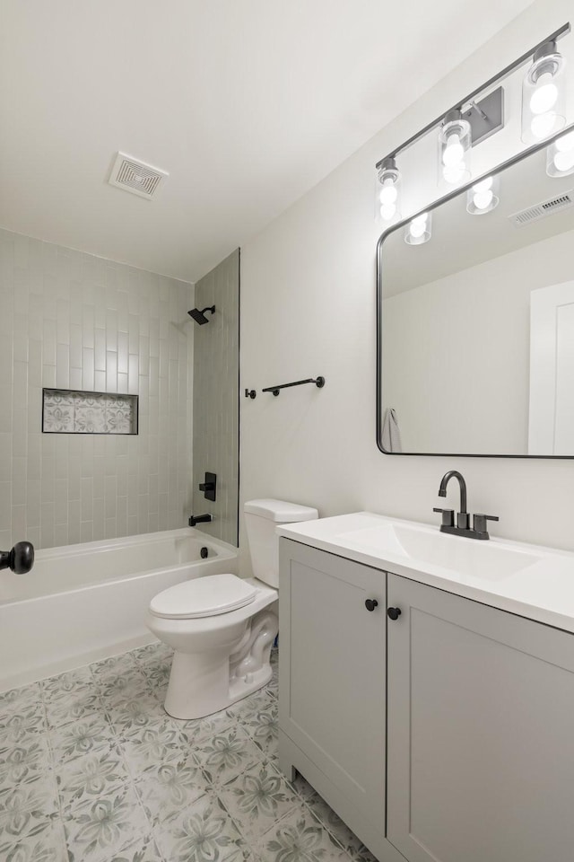 full bathroom featuring vanity, tiled shower / bath combo, and toilet