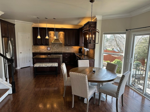 dining space featuring sink, ornamental molding, dark hardwood / wood-style floors, and a chandelier