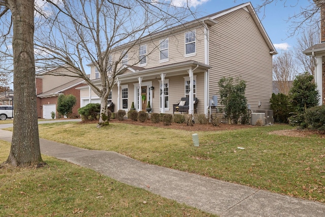 view of front of house with a garage, a front yard, central AC unit, and covered porch