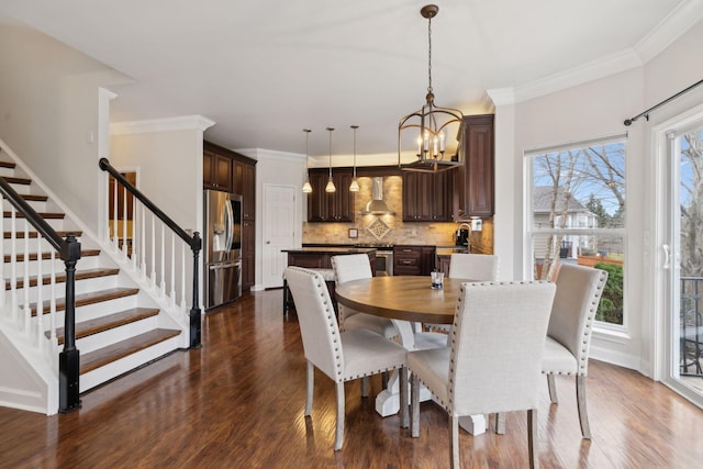 dining area featuring ornamental molding, dark wood-type flooring, sink, and a chandelier