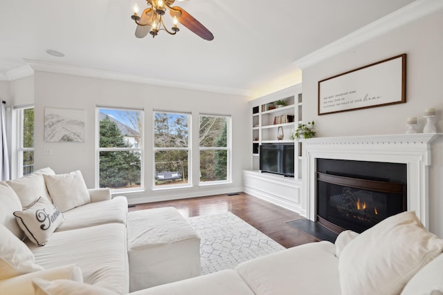 living room with crown molding, dark hardwood / wood-style floors, and built in features