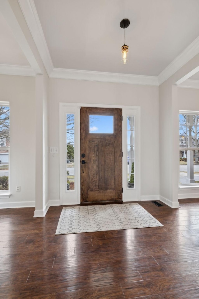 foyer entrance featuring crown molding, plenty of natural light, and dark wood-type flooring