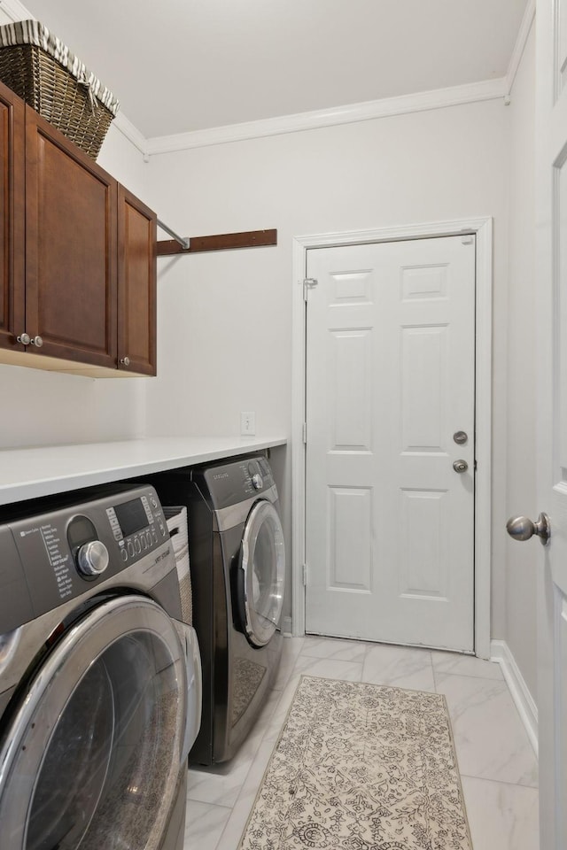 clothes washing area with crown molding, washing machine and dryer, and cabinets